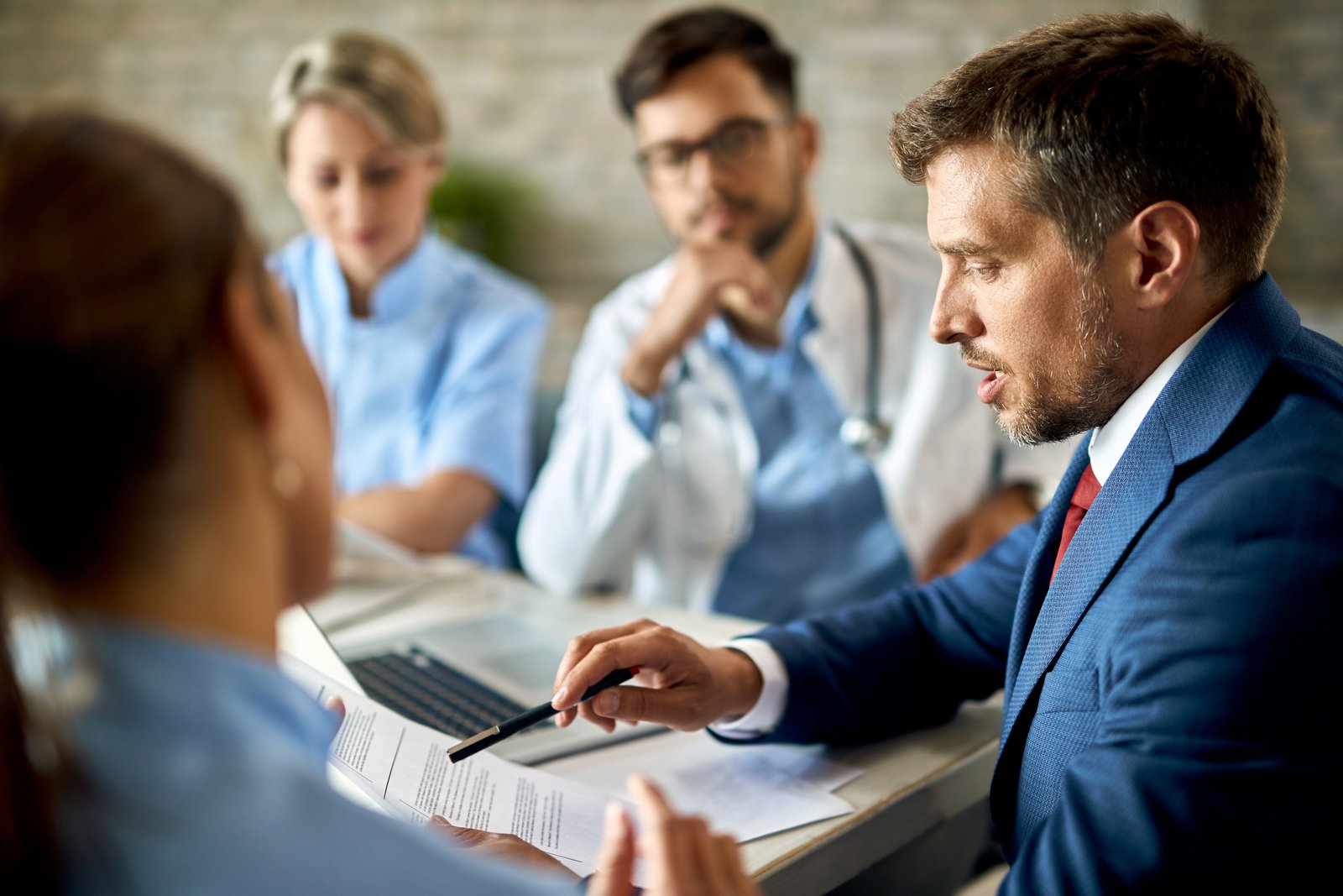 Reunião com profissionais de saúde analisando documentos